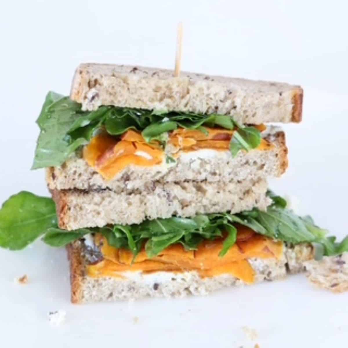 Two halves of a goat cheese sandwich stacked on top of each other.