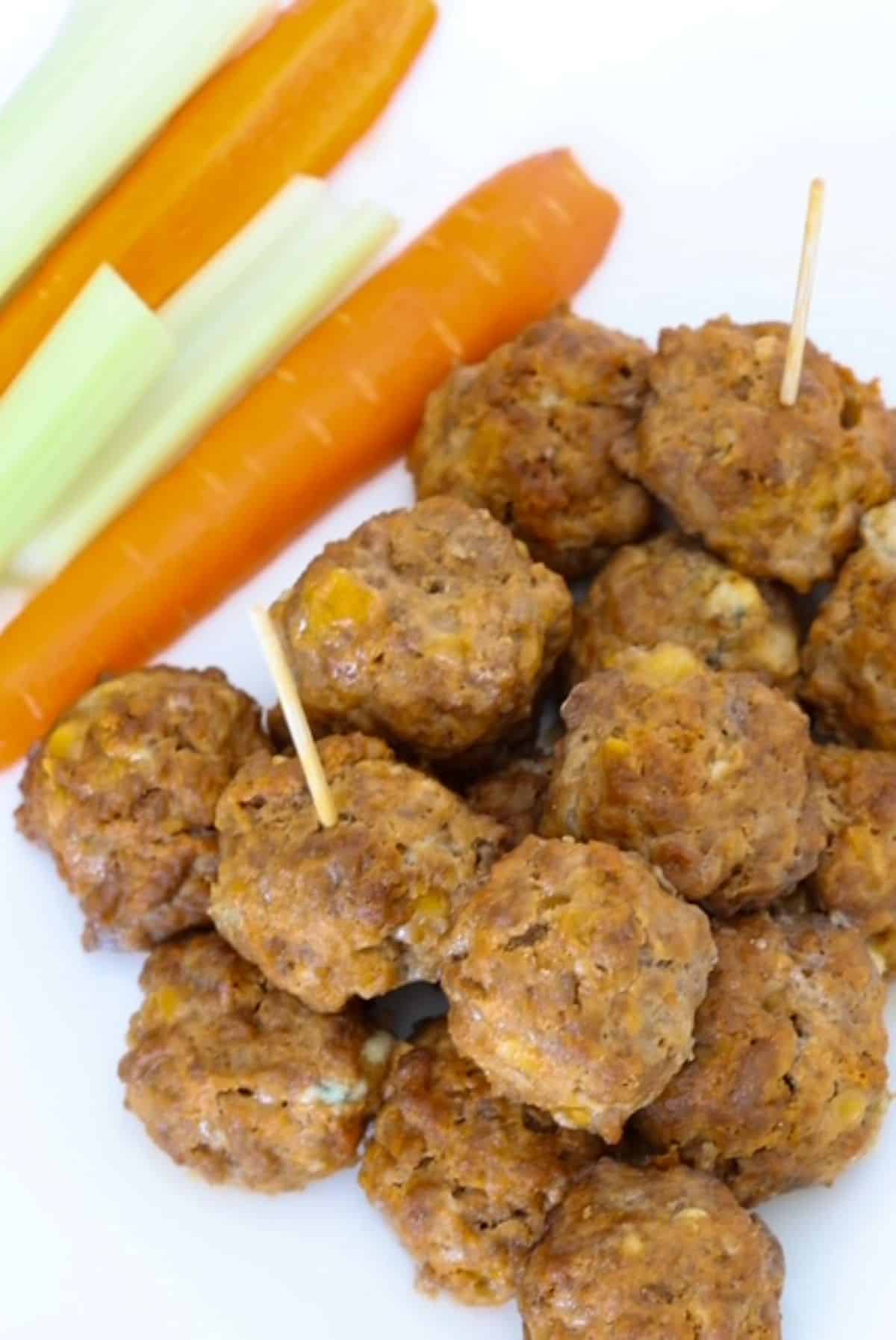 Top view of Buffalo Chicken Meatballs with carrots and celery sticks.